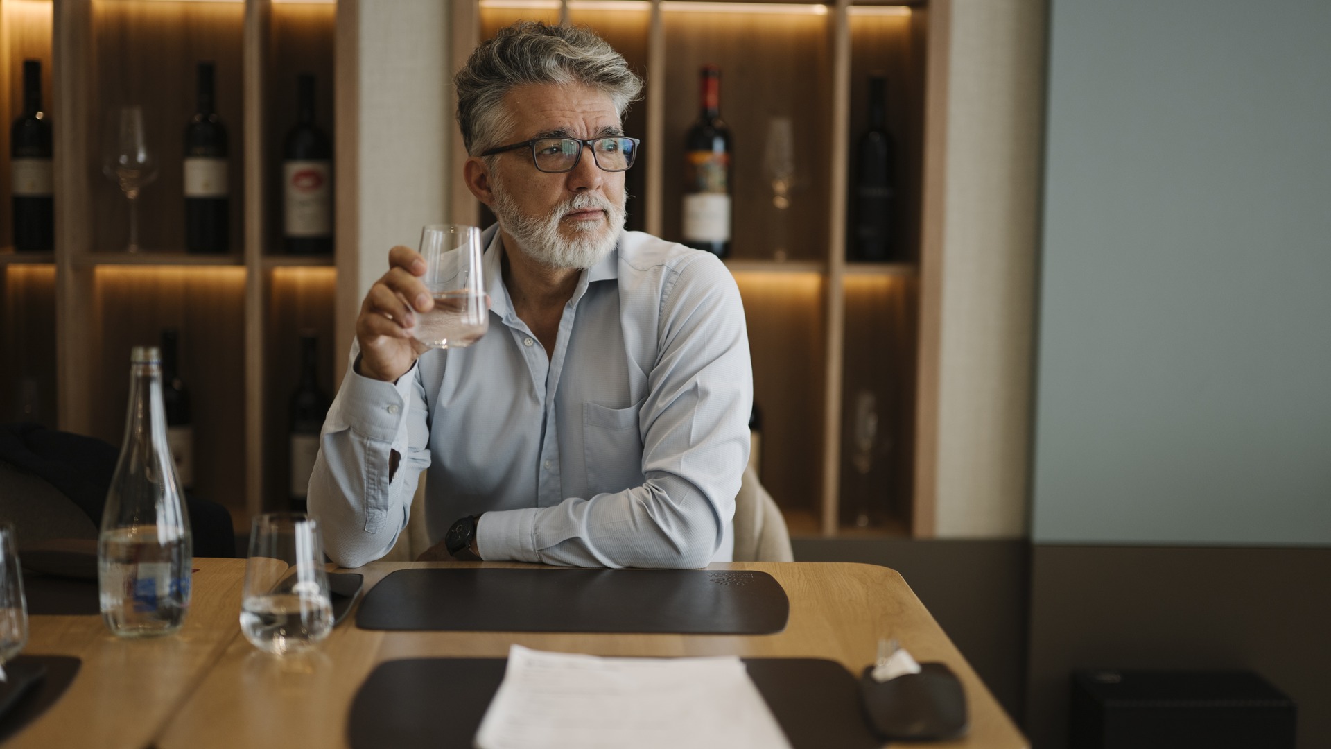 Client au restaurant avec cave a vins en arriere-plan - coefficient et prix du vin au restaurant