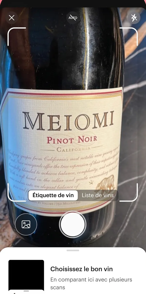 Écran de scan de l’application Vivino : une bouteille de pinot noir cadrée dans le viseur, onglets Étiquette de vin et Liste de vins, bouton de prise de vue.