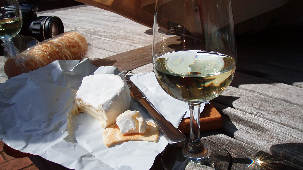 Verre de vin blanc sec accompagné d'un plateau de fromages