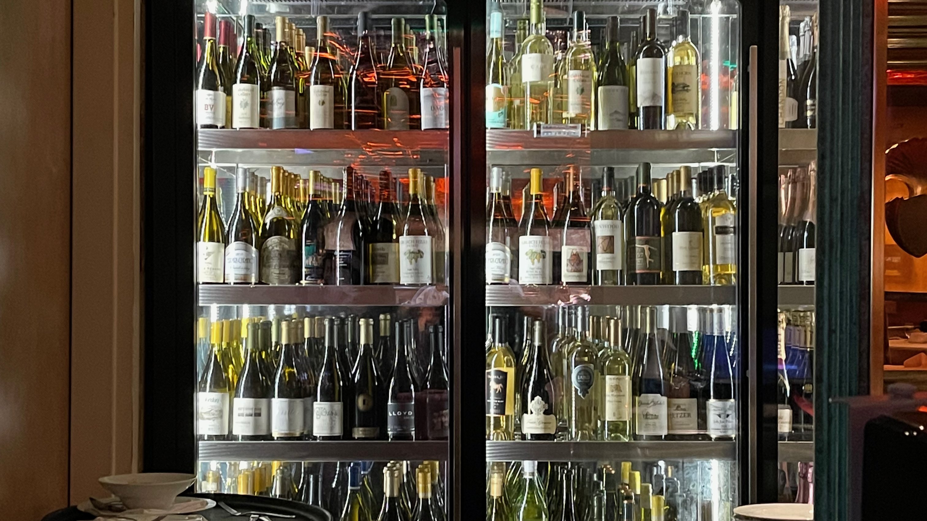 Armoires à vin réfrigérées à portes vitrées remplies de bouteilles
