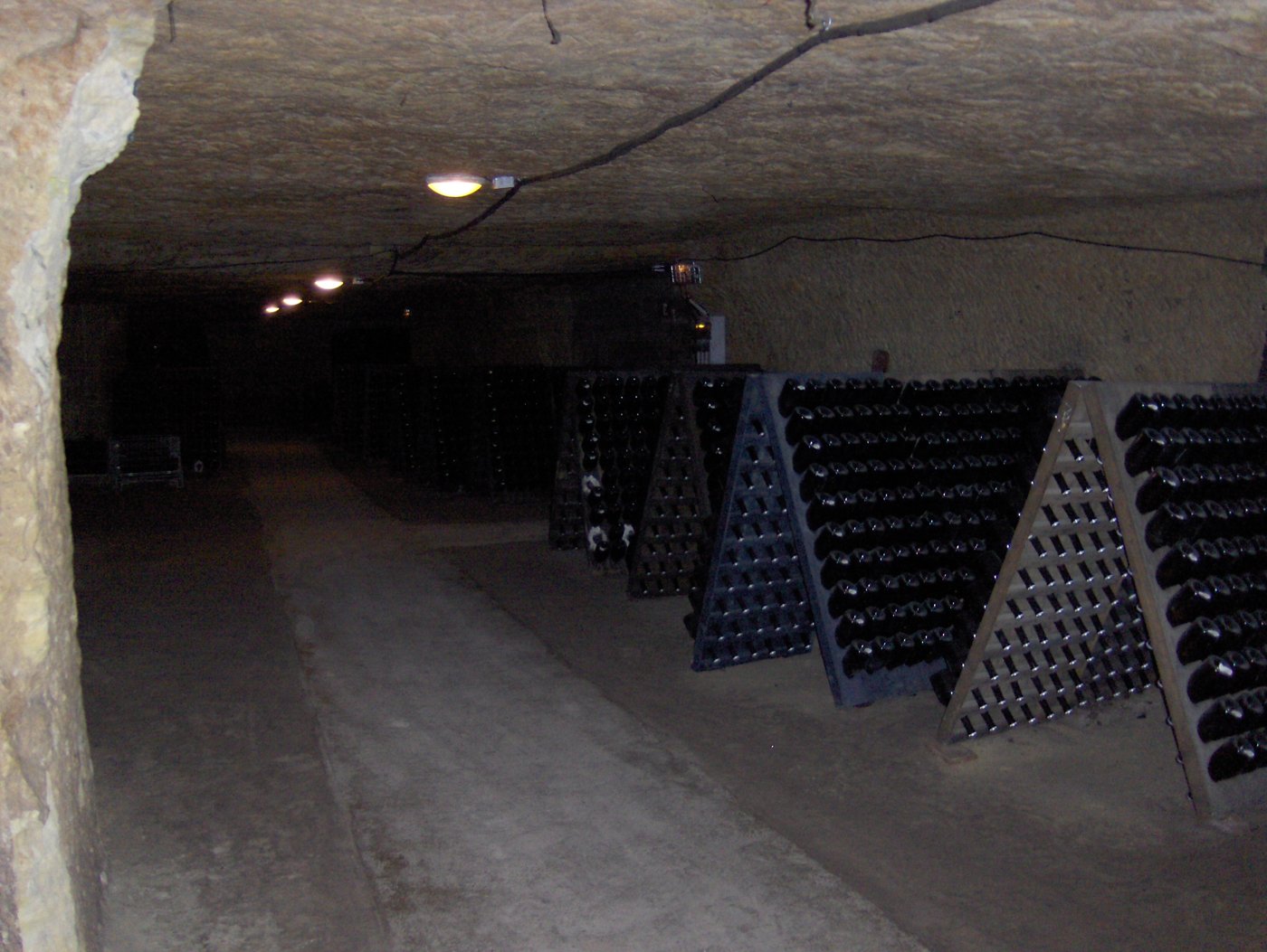 Galerie de cave creusée dans le tuffeau à Vouvray, avec des pupitres de bouteilles