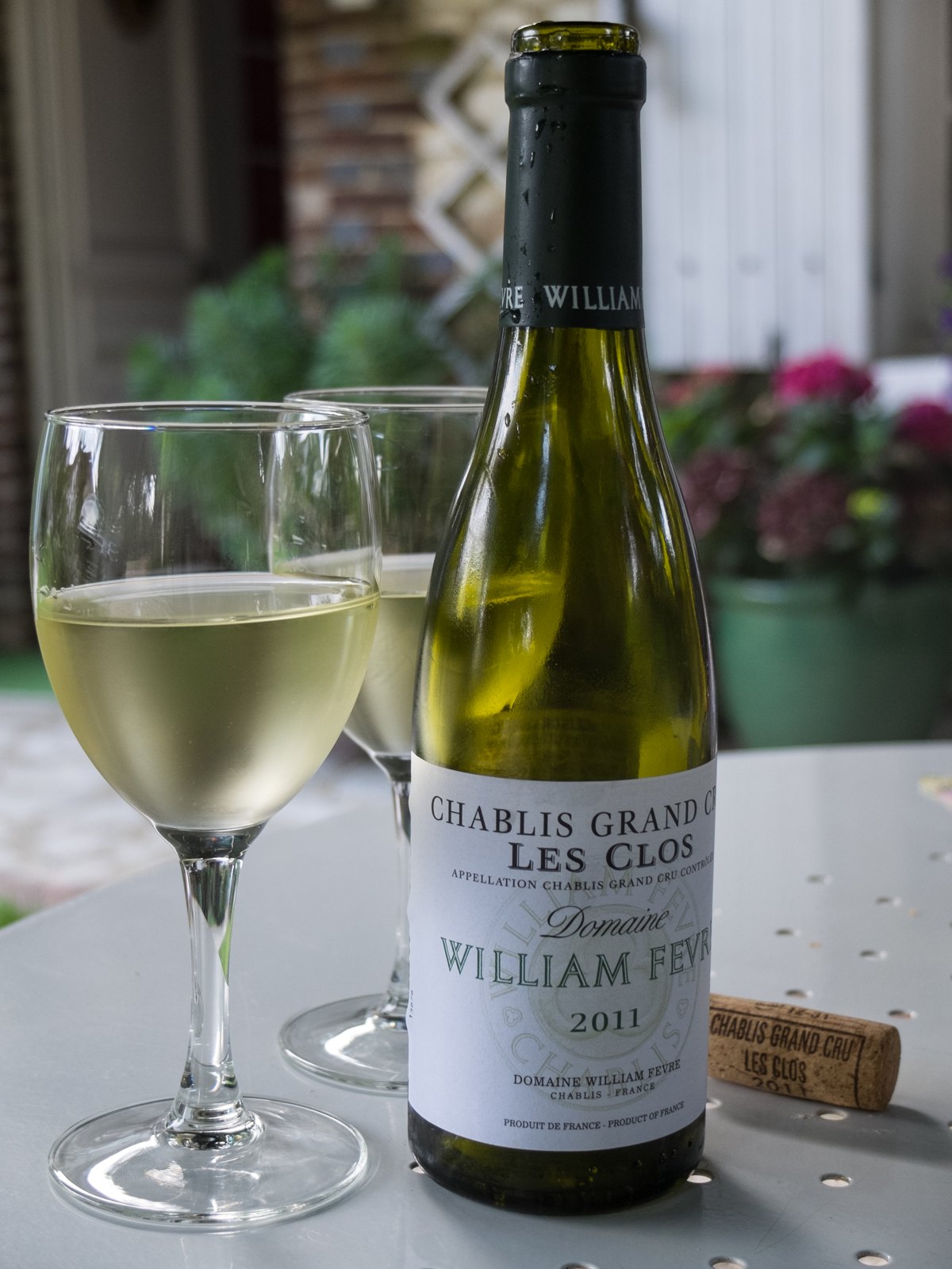 Bouteille de Chablis Grand Cru Les Clos du Domaine William Fèvre et deux verres de vin blanc