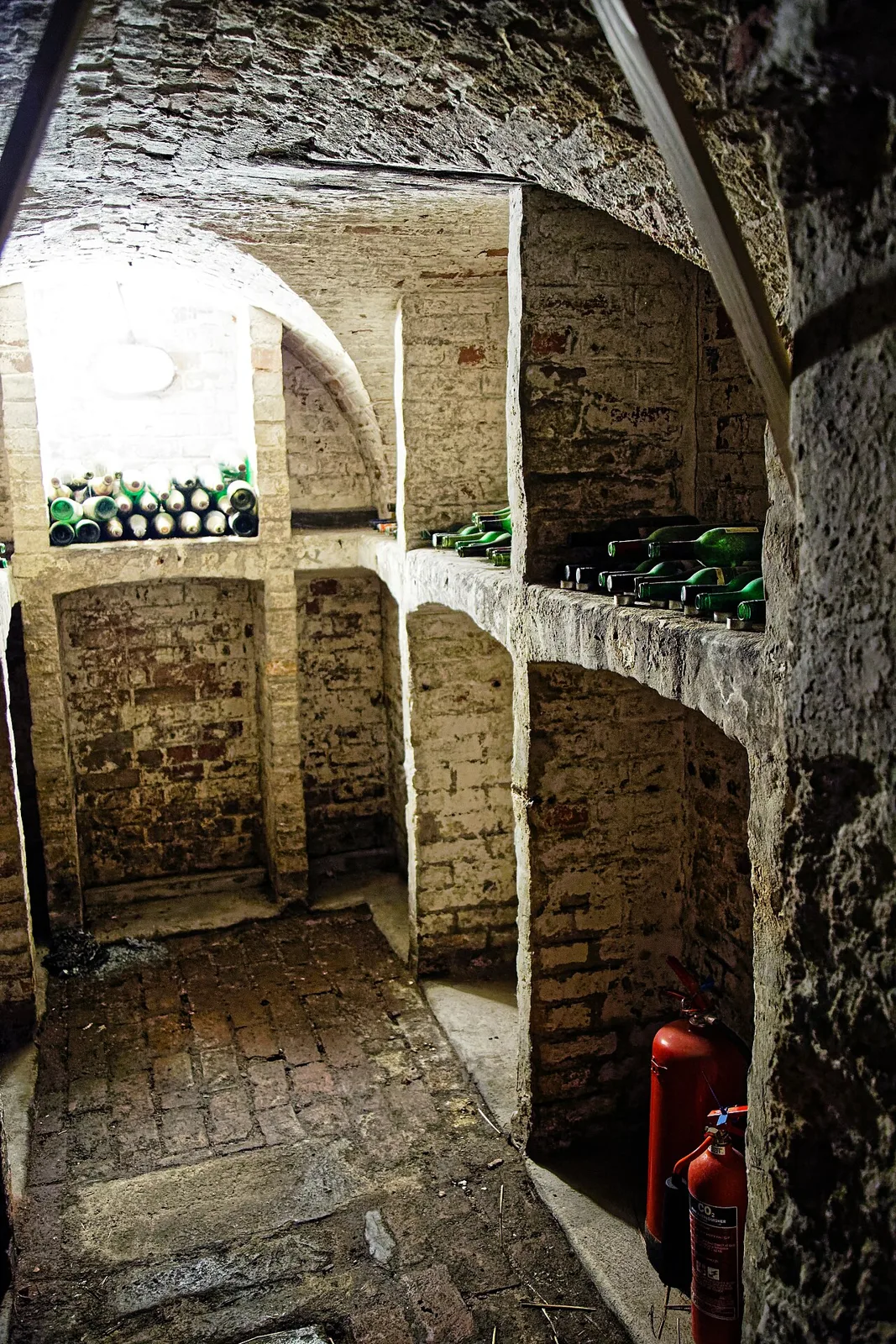 Cave voûtée en briques avec bouteilles couchées dans des niches