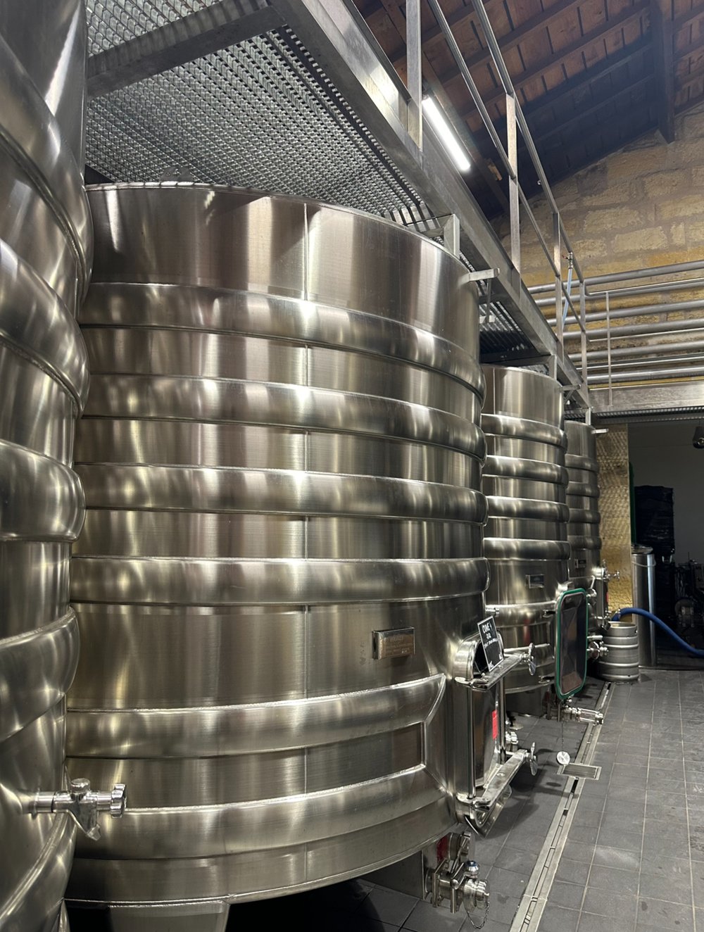 Cuves de fermentation en inox thermorégulées dans un chai bordelais