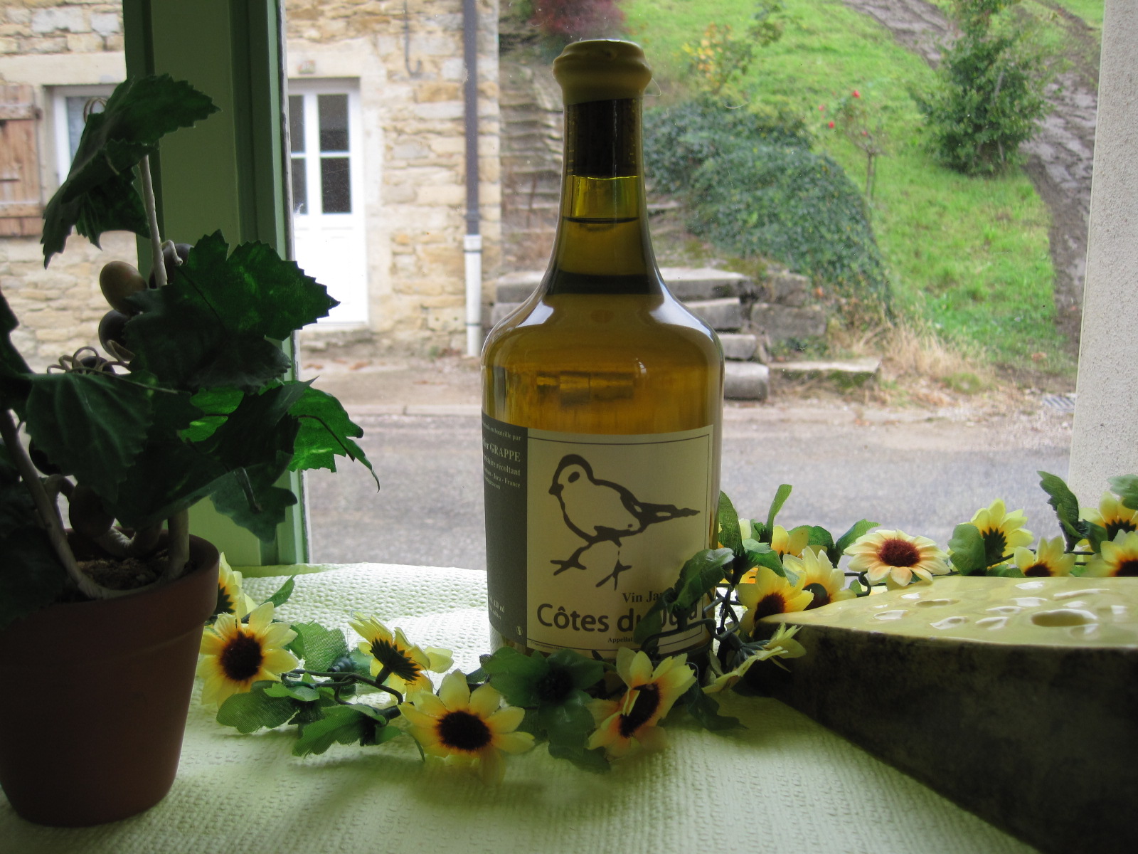 Vrai clavelin de vin jaune du Jura posé près d'une fenêtre