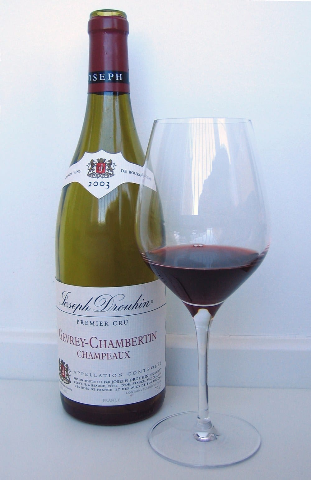 Bouteille de Joseph Drouhin Gevrey-Chambertin premier cru 2003 et verre de vin rouge