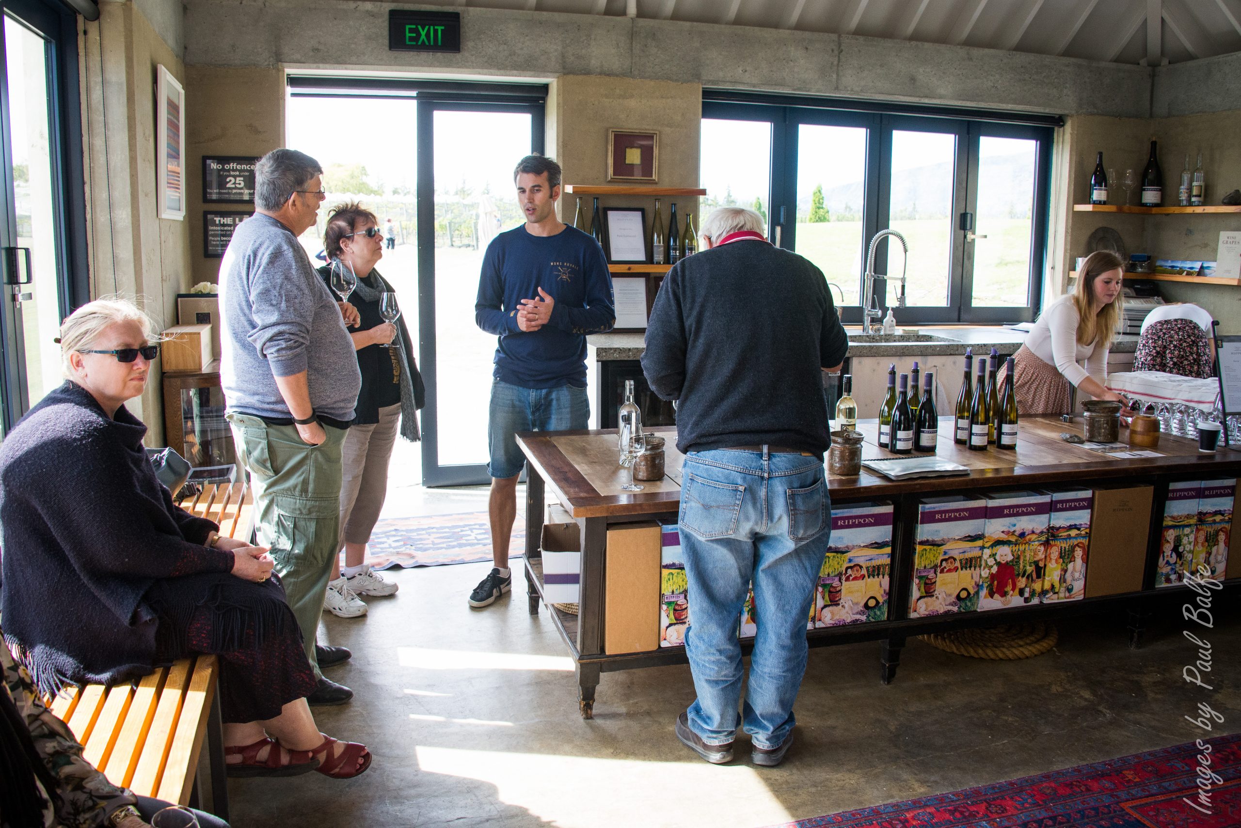 Dégustation de vin dans un domaine, avec des visiteurs autour du comptoir